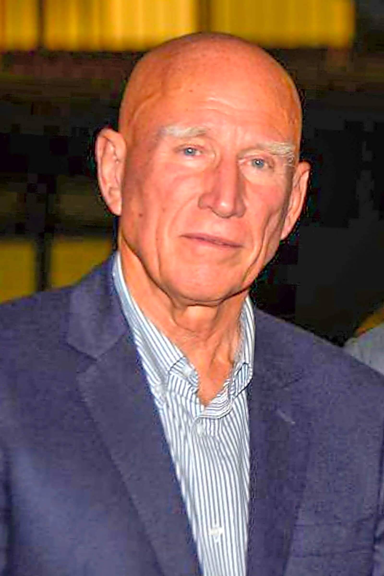 Fotografia em preto e branco de Sebastião Salgado em cena de campo, com fundo de terra e vegetação, capturando a essência do artista.