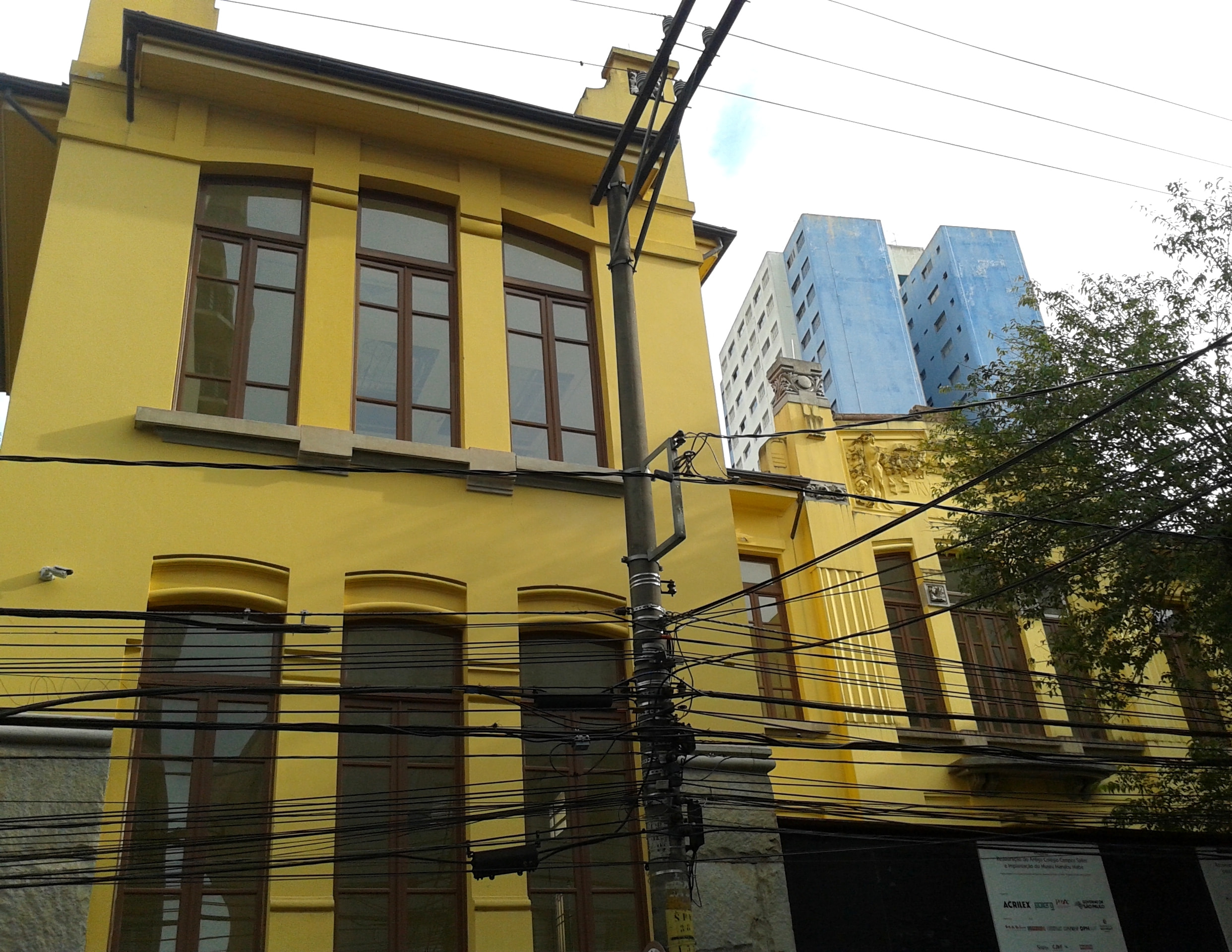 Pintura a óleo de Manabu Mabe, mostrando uma mistura de estilos orientais e ocidentais em tons de azul e verde pastel, com elementos geométricos.